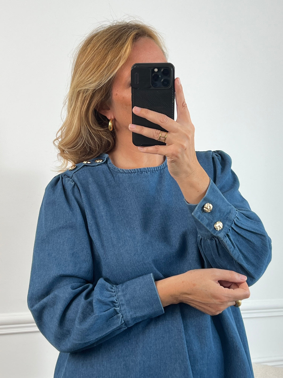 Robe en jean grande taille femme au style casual chic. Col rond et coupe droite moderne, idéale au quotidien comme en sortie. Détails raffinés : boutons dorés aux poignets et à l’épaule. Bleu intemporel, 100% coton pour allier confort et élégance.