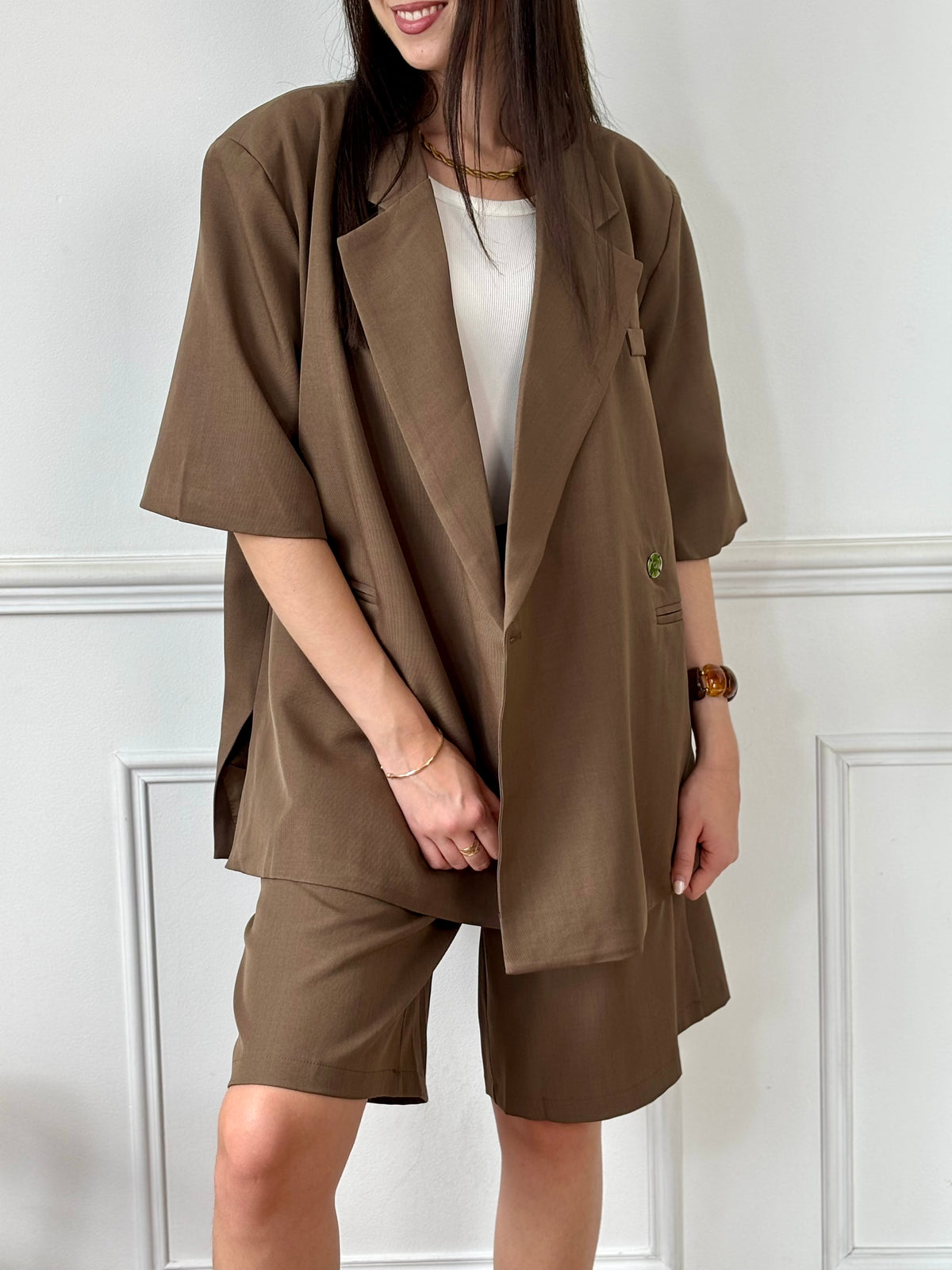 Ce bermuda taupe Delfine allie confort et praticité avec sa taille élastique au dos et ses passants pour ceinture. Il dispose de deux poches latérales et d’une poche arrière, offrant un espace de rangement fonctionnel. Sa fermeture éclair et son bouton à l’avant assurent un maintien sûr tout au long de la journée.