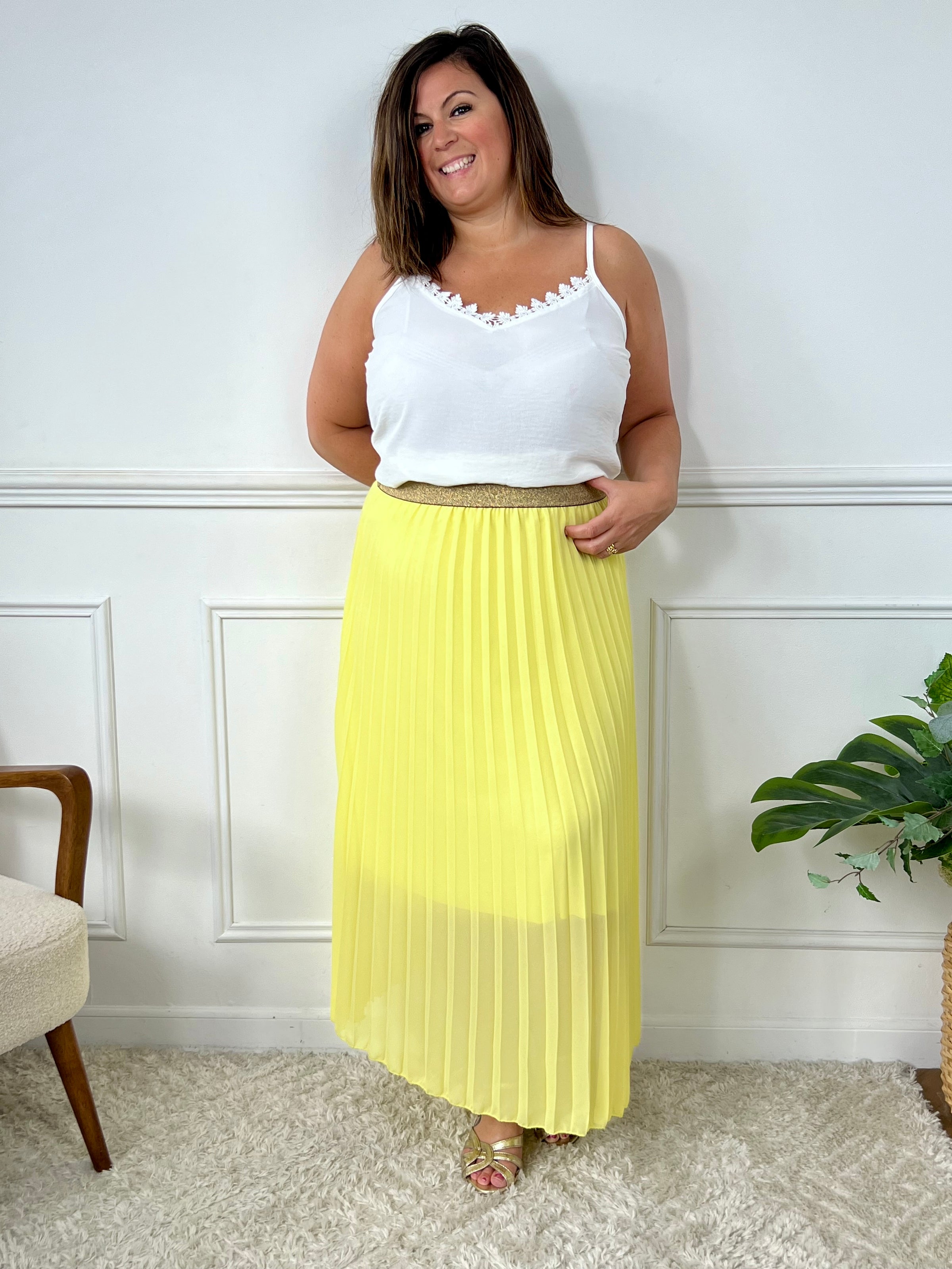 La jupe jaune plissée de grande taille incarne une élégance intemporelle. Avec sa coupe longue et plissée, elle offre une silhouette flatteuse et tendance. Cette pièce allie style et confort, créant une tenue sophistiquée et moderne pour les femmes de grande taille.
