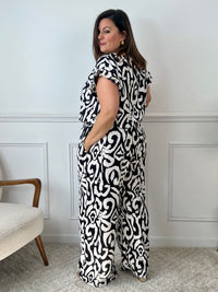 Léger et éclatant, ce top fluide noir et écru sans manches séduit par ses jolis volants aux épaules. Une pièce pleine de fraîcheur et de féminité, parfaite pour égayer vos looks avec une touche raffinée.