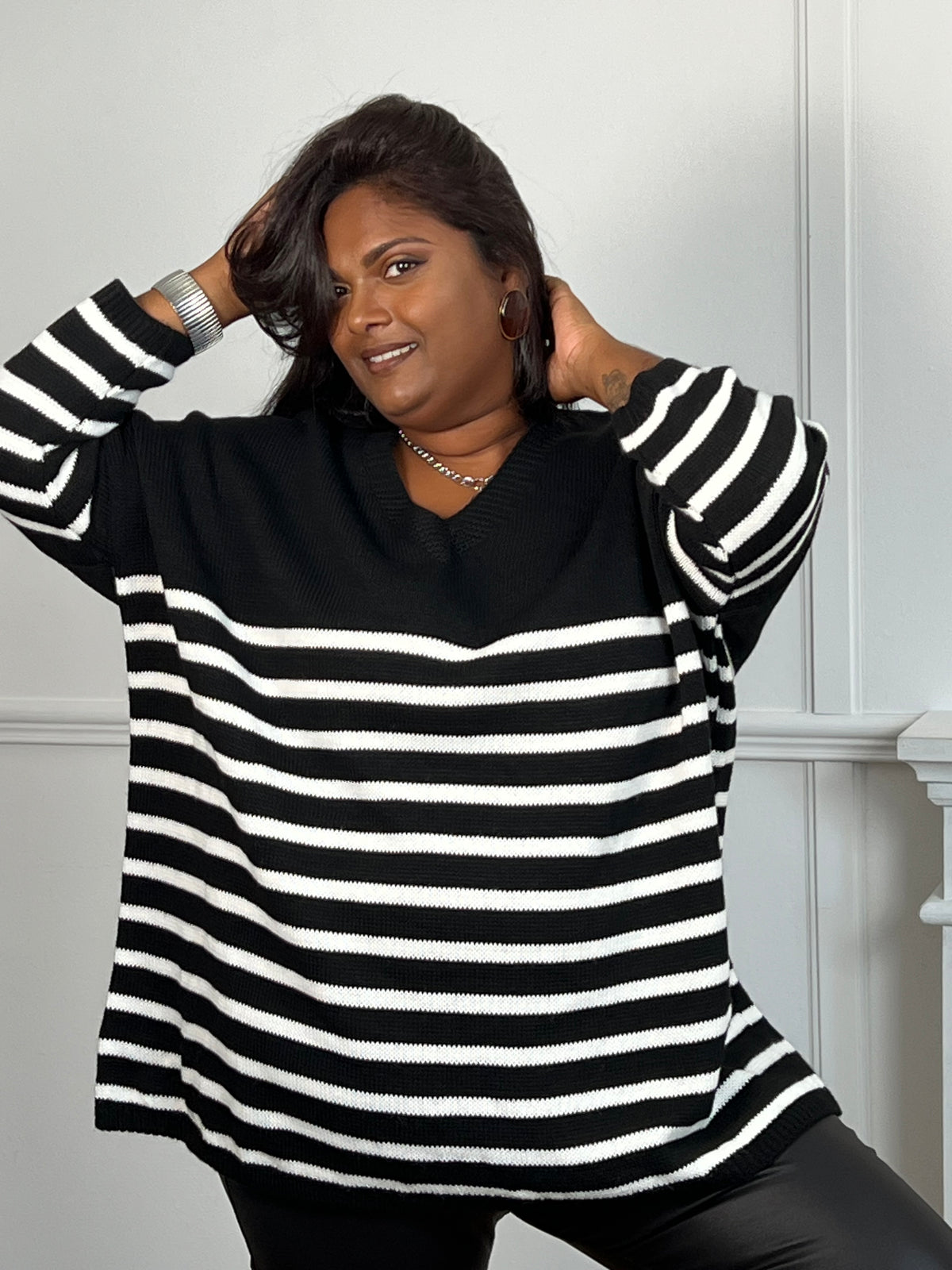 Ce pull noir grande taille Noemie combine confort et style avec ses manches courtes et son col en V flatteur. Son tissu ample offre une coupe décontractée idéale pour toutes les morphologies, tandis que les rayures écrues façon marinière ajoutent une touche élégante et intemporelle.