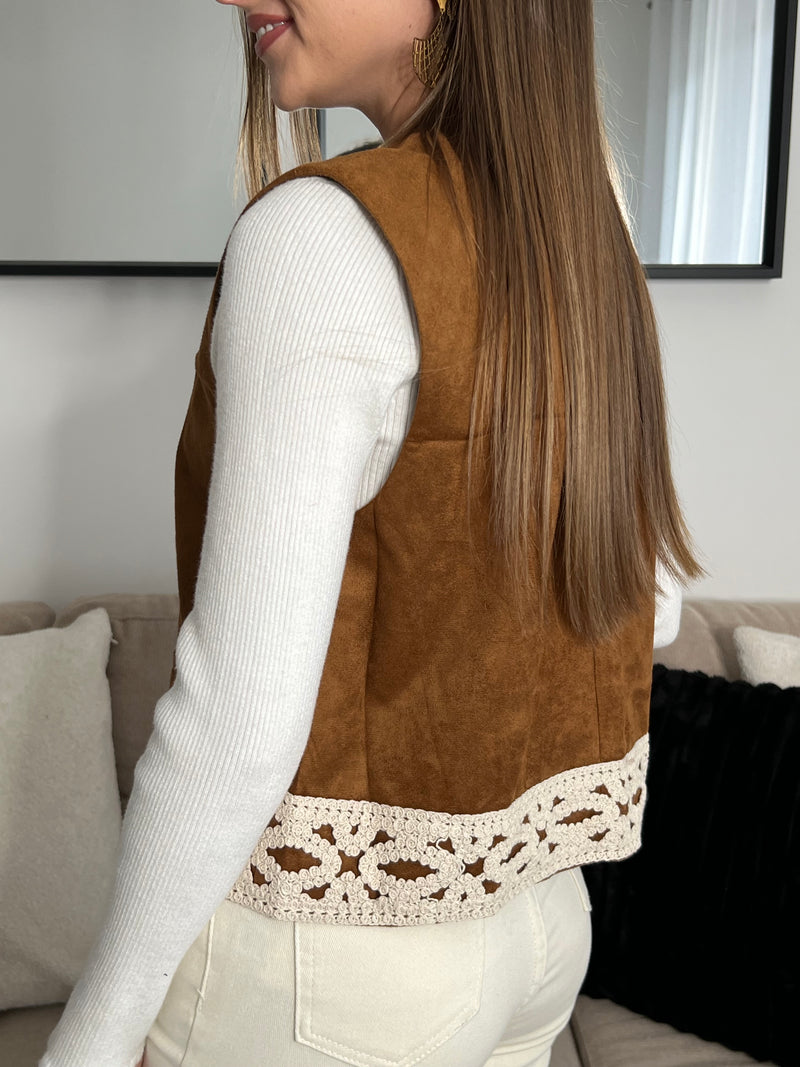 Adoptez un style chic et intemporel avec cette veste sans manches camel, sublimée par des détails de broderie écru. Parfaite pour ajouter une touche d'élégance à vos tenues tout en restant confortable et tendance.