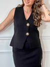 Ce gilet sans manches noir, nommé Elvire, allie élégance et originalité. Sa fermeture à boutons sur toute la longueur est sublimée par un détail doré en forme de soleil, apportant une touche lumineuse à votre tenue. Son col en V flatteur met en valeur votre silhouette, tandis que sa coupe sans manches offre confort et liberté de mouvement.