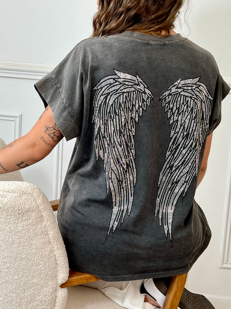 Tee-shirt gris au style affirmé, sublimé par un motif ailes d’ange en strass dans le dos. Un mélange parfait de douceur et d’éclat, pour un look casual qui ne passe pas inaperçu.