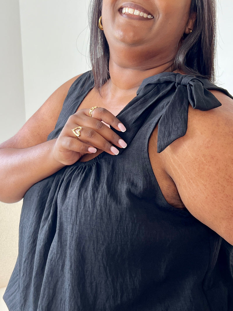 Adoptez un look élégant et confortable avec ce top noir grande taille. Ses bretelles non réglables sont agrémentées d’un détail nœud au niveau des épaules, apportant une touche féminine et raffinée. Sa couleur noire intemporelle en fait une pièce facile à associer à vos tenues du quotidien comme aux looks habillés