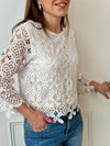Cette blouse écrue est ornée de broderies délicates, avec des manches longues en broderie et un col rond. Pratique avec ses boutons au dos et doublée à l'avant, elle ajoute une touche de délicatesse à votre garde-robe avec ses détails ajourés et sa couleur écru.