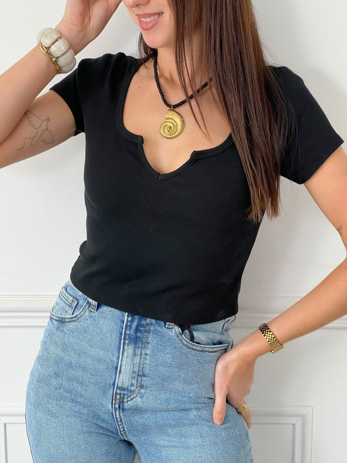 Un top noir intemporel, d'une simplicité élégante et polyvalente, idéal pour compléter n'importe quelle tenue avec style et décontraction. Sa couleur neutre s'harmonise parfaitement avec une variété de looks.