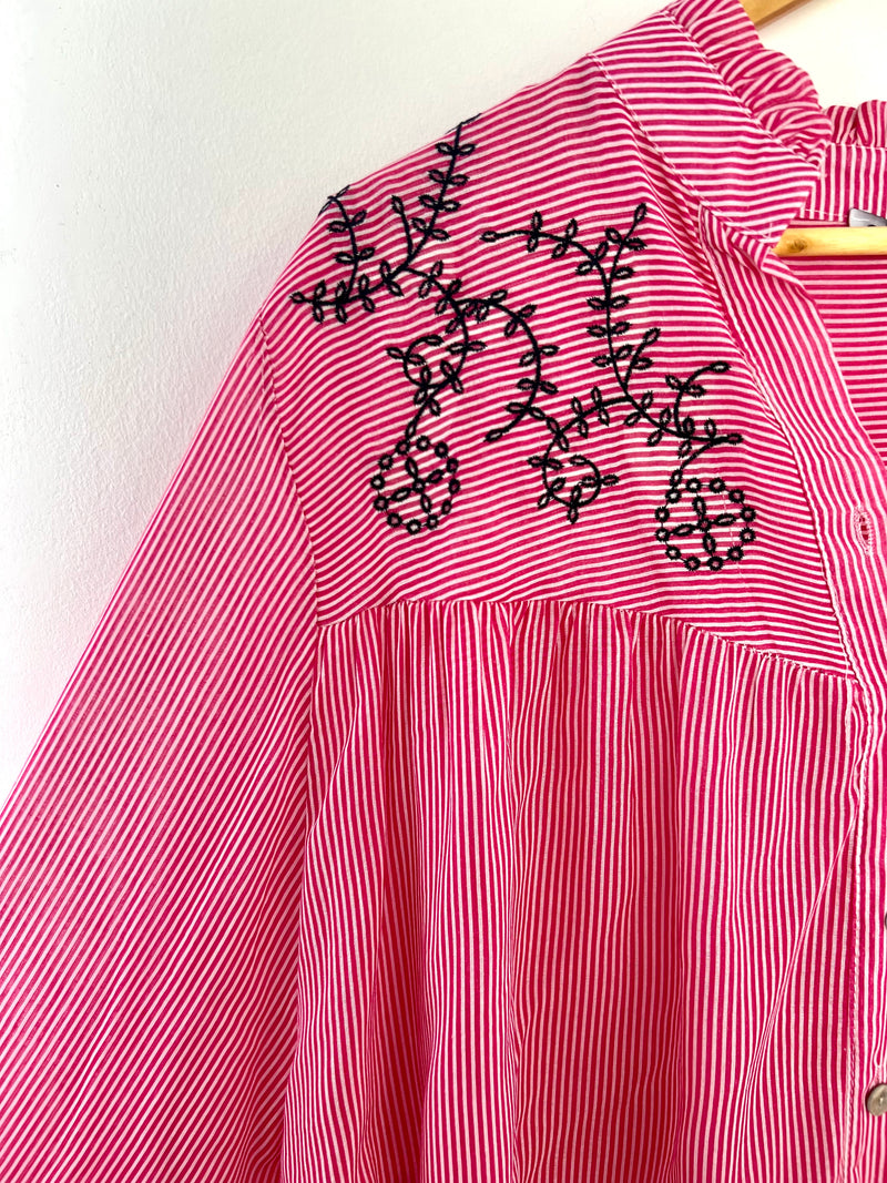 Découvrez la chemise rose à rayures Clia ! Avec ses rayures rose et écru et sa broderie noire, elle apporte une touche d'élégance à votre tenue. Confortable et tendance, elle sera parfaite pour toutes les occa