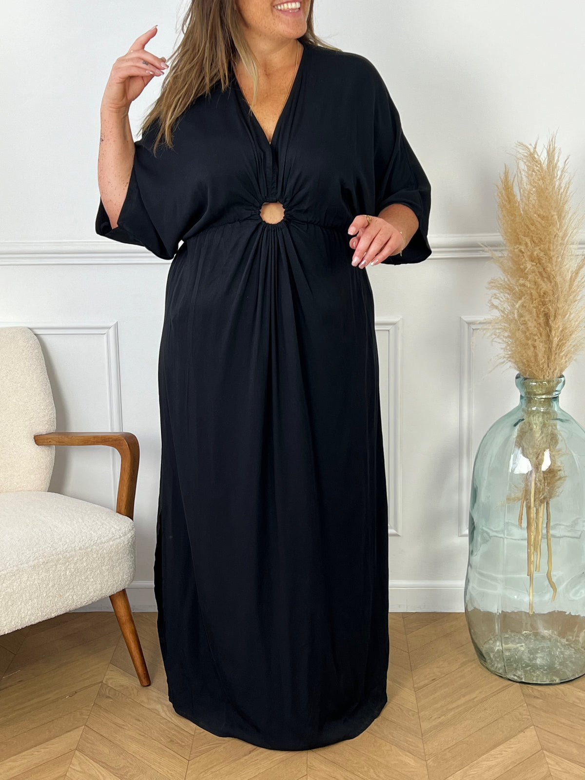 La robe Alwena noire est la pièce parfaite pour toutes les occasions. Avec son col V flatteur et sa coupe ample, elle s'adapte à toutes les tailles. Son élasticité à la taille offre confort et élégance, tandis que sa couleur noire intemporelle apporte une touche de fluidité à votre garde-robe.