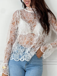 Cette blouse écrue Evelina allie délicatesse et élégance. Confectionnée en broderie ajourée, elle offre une touche de légèreté et de fraîcheur. Son col rond orné de volants apporte une note féminine raffinée, tandis que les deux boutons sur le devant facilitent l’enfilage.