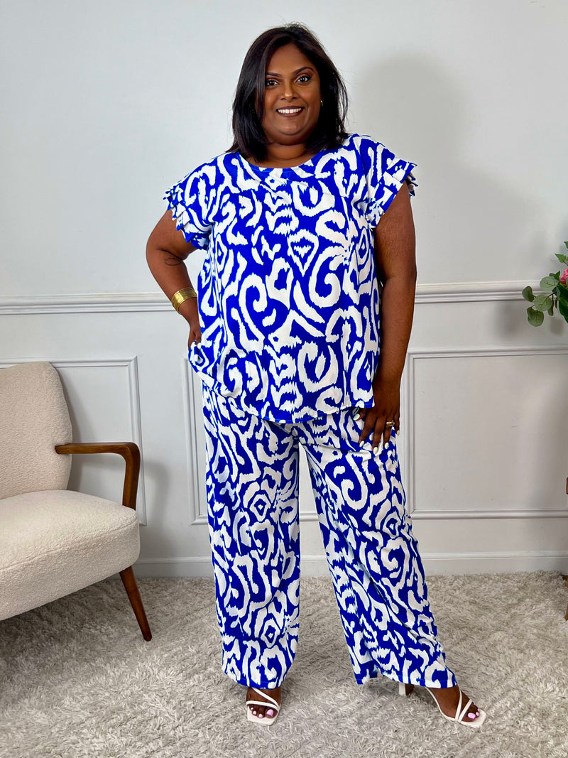 Léger et éclatant, ce top fluide bleu et écru sans manches séduit par ses jolis volants aux épaules. Une pièce pleine de fraîcheur et de féminité, parfaite pour égayer vos looks avec une touche raffinée.