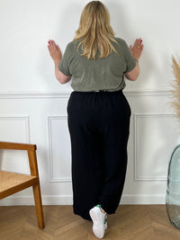 Le pantalon fluide noir Alanis est un incontournable pour votre garde-robe. Avec une taille haute confortable et élastique au dos, ce pantalon large vous assure un ajustement parfait. La ceinture amovible ajoute une touche de peps à votre tenue.