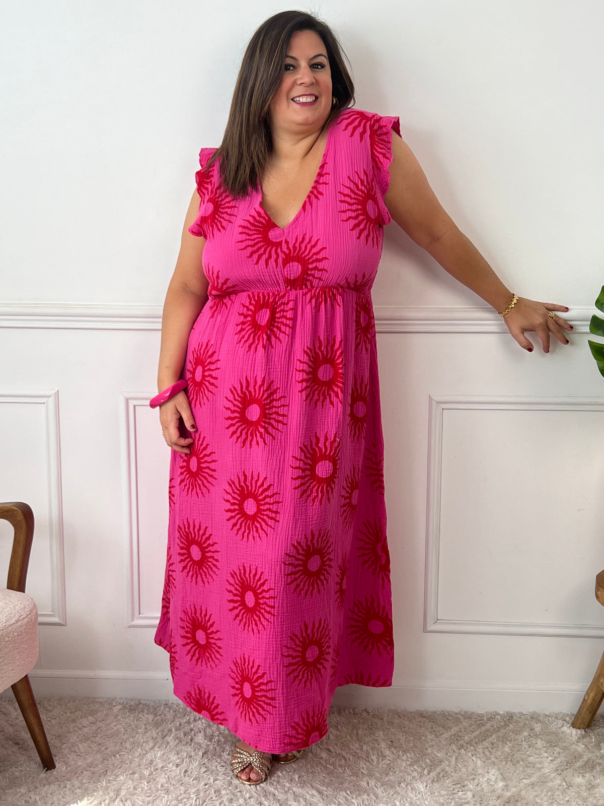 Célébrez vos courbes avec notre robe longue Clelie en fuchsia vibrant. Conçue avec soin pour les grandes tailles, elle vous enveloppe de confiance grâce à ses motifs harmonieux et ses volants gracieux aux épaules.