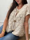 Ce gilet sans manches beige, Gaela, allie simplicité et élégance avec son col rond classique. Les broches dorées sur le devant ajoutent une touche sophistiquée, rehaussant discrètement votre look tout en restant confortable et facile à porter.