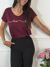 Ce tee-shirt bordeaux "Aliyah" allie confort et élégance avec ses manches courtes et son col rond classique. Sa touche distinctive, une inscription dorée sur le devant, apporte une subtile note de sophistication. Idéal pour un style décontracté mais soigné au quotidien.