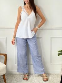Transformez votre look avec le top Larah ! Fabriqué en gaze de coton écru, avec des bretelles et un col en broderie, son dos élastique offre un confort sans égal.