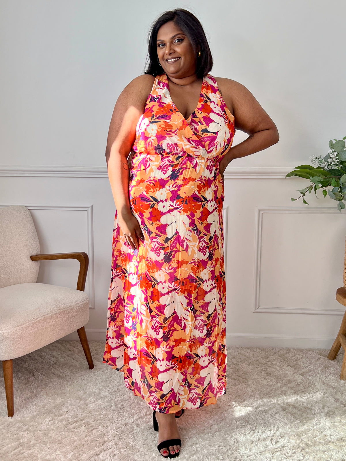 Découvrez notre robe longue Manuela en orange, avec un délicat motif floral et des détails dorés pour un look lumineux. Avec son col cache cœur à l'avant et à l'arrière, elle est à la fois élégante et confortable grâce à son élastique à la taille et son lien à nouer à la nuque. Parfaite pour une soirée d'été !