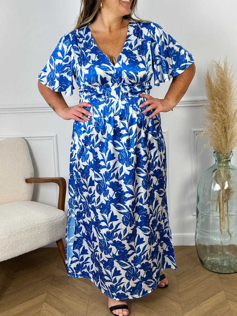 Découvrez notre magnifique robe longue "Livio" bleue et écrue pour femme. Avec ses manches courtes et son col V, elle est à la fois élégante et confortable. La taille élastique souligne votre silhouette tandis que le motif floral et les fentes latérales ajoutent une touche de féminité.