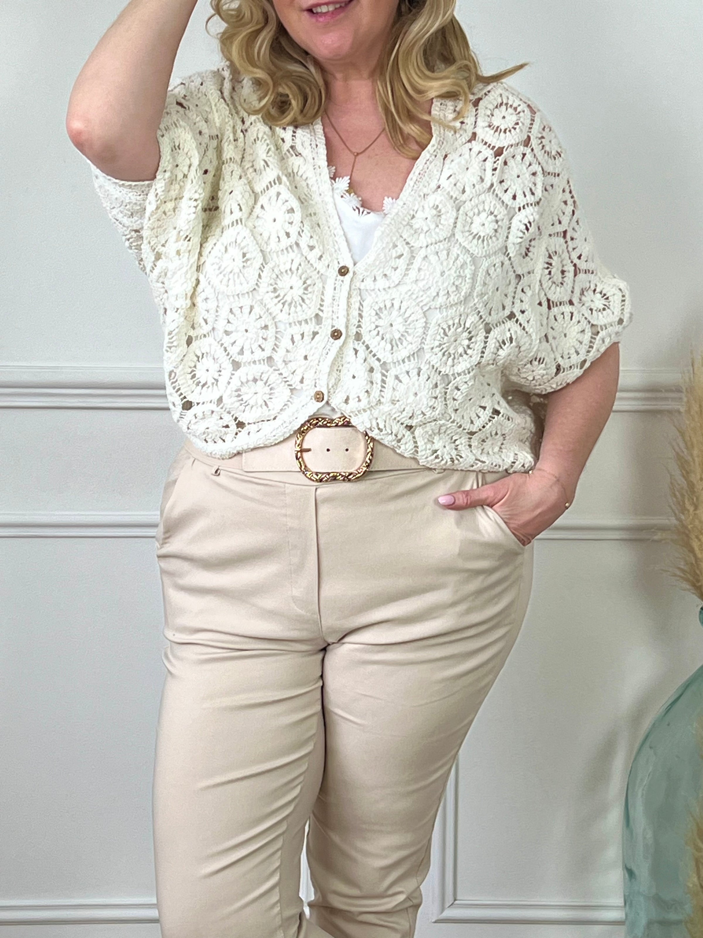 Optez pour le confort et le style avec notre gilet crochets écru Ela. Confectionné avec du tissu de qualité, ce gilet est orné d'une broderie élégante et de boutons marrons le long de la fermeture. Avec son design intemporel, il ajoutera une touche de sophistication à toutes vos tenues.