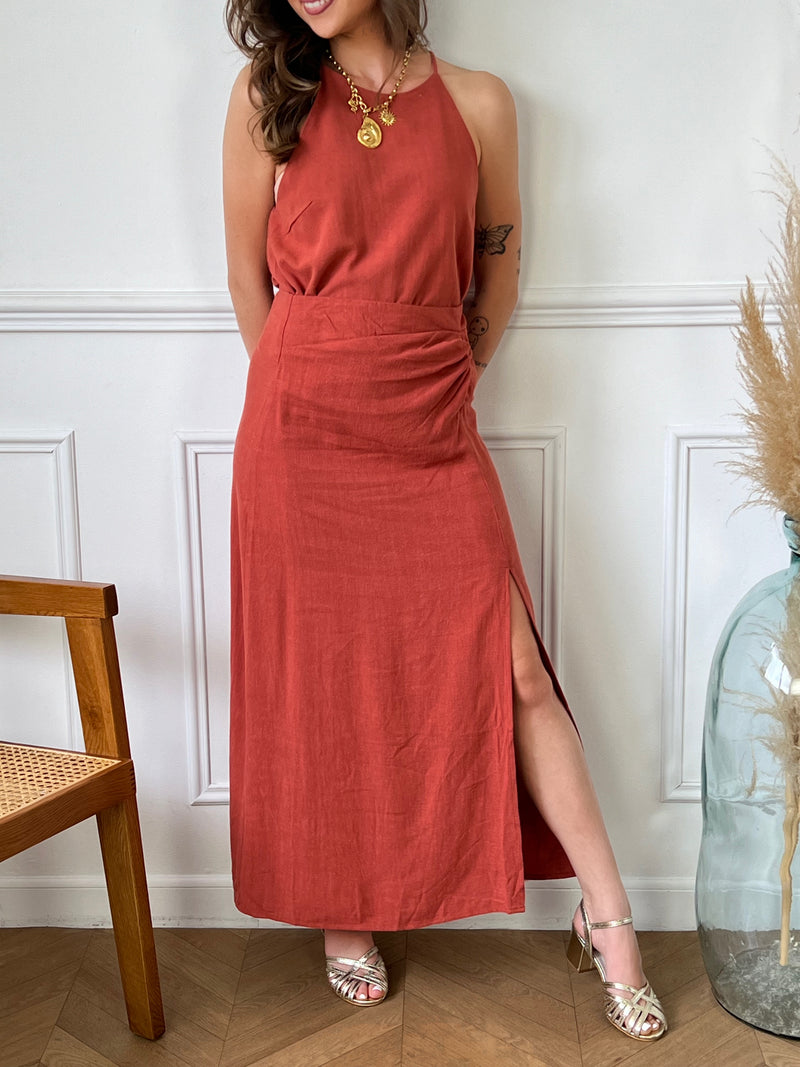 Cette jupe longue terracotta Falia est à la fois élégante et pratique. Avec sa fente sur le devant, elle vous donnera une grande liberté de mouvement tout en vous offrant une allure sophistiquée.Parfait pour un look chic et décontracté à la fois.