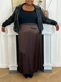 Cette jupe longue en satin marron, modèle Lola, allie élégance et confort grâce à sa taille élastique qui s'adapte parfaitement à toutes les morphologies.