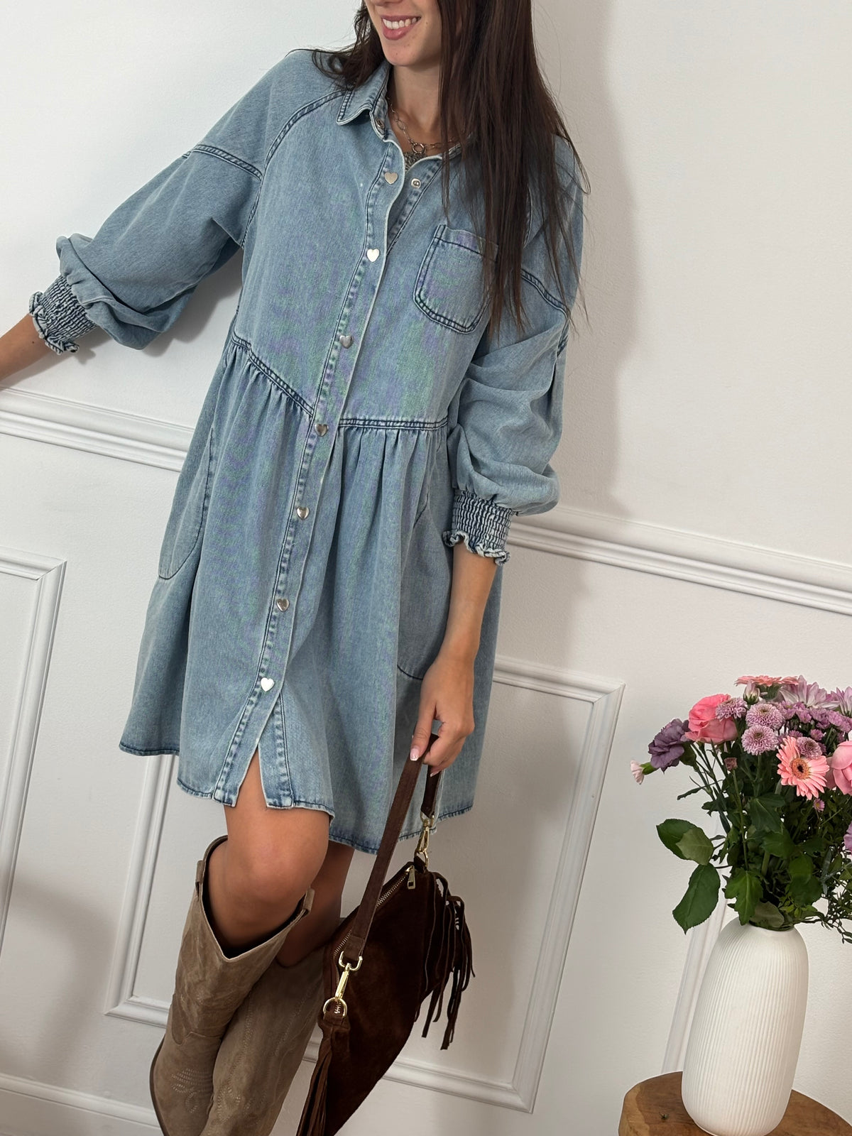 Robe en jean bleu clair Anita, courte et confortable. Manches longues avec élastique aux poignets, col chemise, boutons en forme de cœur et deux poches latérales. Coupe ample pour plus de liberté.