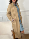 Trench beige femme avec ceinture, manches longues et col volanté pour une touche féminine. Boutons tout le long, doublure intérieure en carreaux vichy marron et écru, offrant élégance et confort. Coupe ample et deux poches latérales pratiques.
