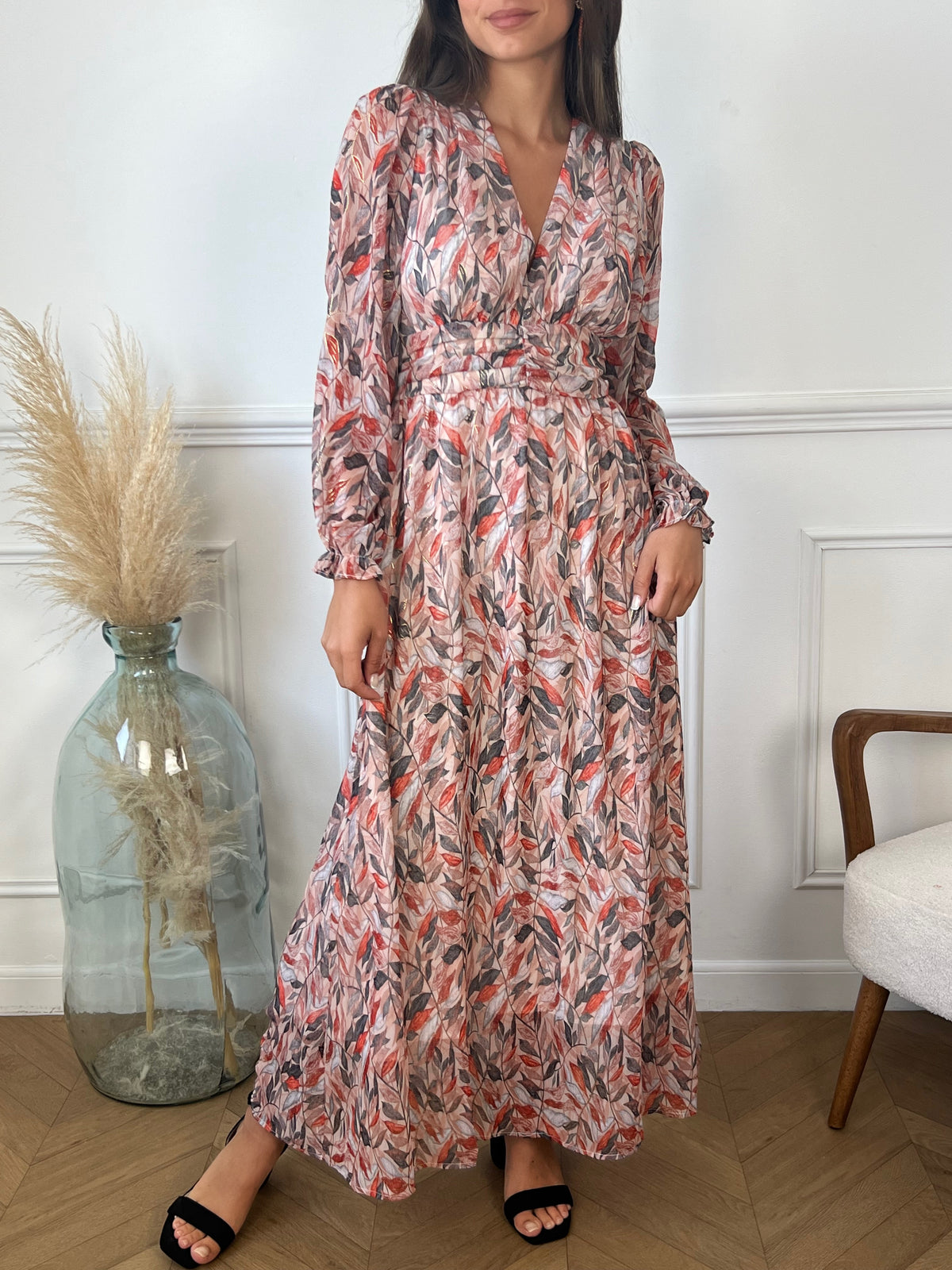 Une robe longue avec une taille élastique au dos, qui épouse délicatement la silhouette pour un confort optimal. Elle se distingue par ses motifs aux tons rose, gris, et terracotta, qui créent un mélange harmonieux de couleurs. Cette robe fluide et féminine est parfaite pour un look à la fois élégant et décontracté, idéale pour les occasions où style et confort vont de pair.