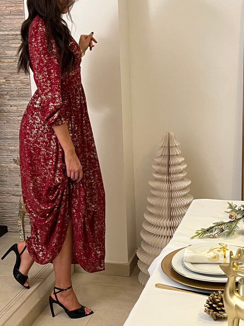 Robe longue festive Malina en bordeaux, parfaite pour vos occasions spéciales. Dotée de manches longues ornées de volants délicats, elle offre une silhouette élégante et féminine.