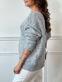 Ce pull gris à manches longues, modèle Elvie, se distingue par ses trois nœuds élégants ornés de détails en strass sur le devant. Confortable et raffiné, il apporte une touche délicate et féminine à vos tenues quotidiennes tout en restant facile à porter.