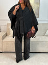 Le Poncho Sorian en gris foncé est la pièce idéale pour un style bohème et fluide. Orné d'une frange latérale élégante et doté d'un passant pour nouer ou fermer, il s'adapte parfaitement à votre silhouette. Confortable et intemporel, ce poncho grande taille accompagne tous vos looks avec grâce.