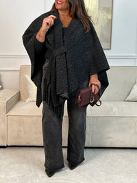 Le Poncho Sorian en gris foncé est la pièce idéale pour un style bohème et fluide. Orné d'une frange latérale élégante et doté d'un passant pour nouer ou fermer, il s'adapte parfaitement à votre silhouette. Confortable et intemporel, ce poncho grande taille accompagne tous vos looks avec grâce.