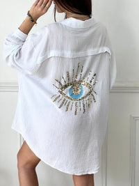 Optez pour la chemise Flore en gaze de coton écrue, avec ses boutons sur la longueur et aux manches, son col chemise et son motif en sequin à l'arrière. Une touche d'originalité pour un look décontracté et tendance. Parfait pour toutes les occasions !