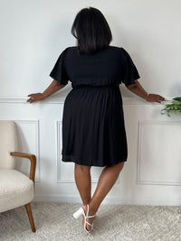 Cette robe courte noire allie confort et élégance grâce à sa taille élastique au dos qui s’adapte parfaitement à votre silhouette. Ses manches courtes et son col en V apportent une touche de fraîcheur, tandis que la doublure en bas assure un tombé fluide et agréable.