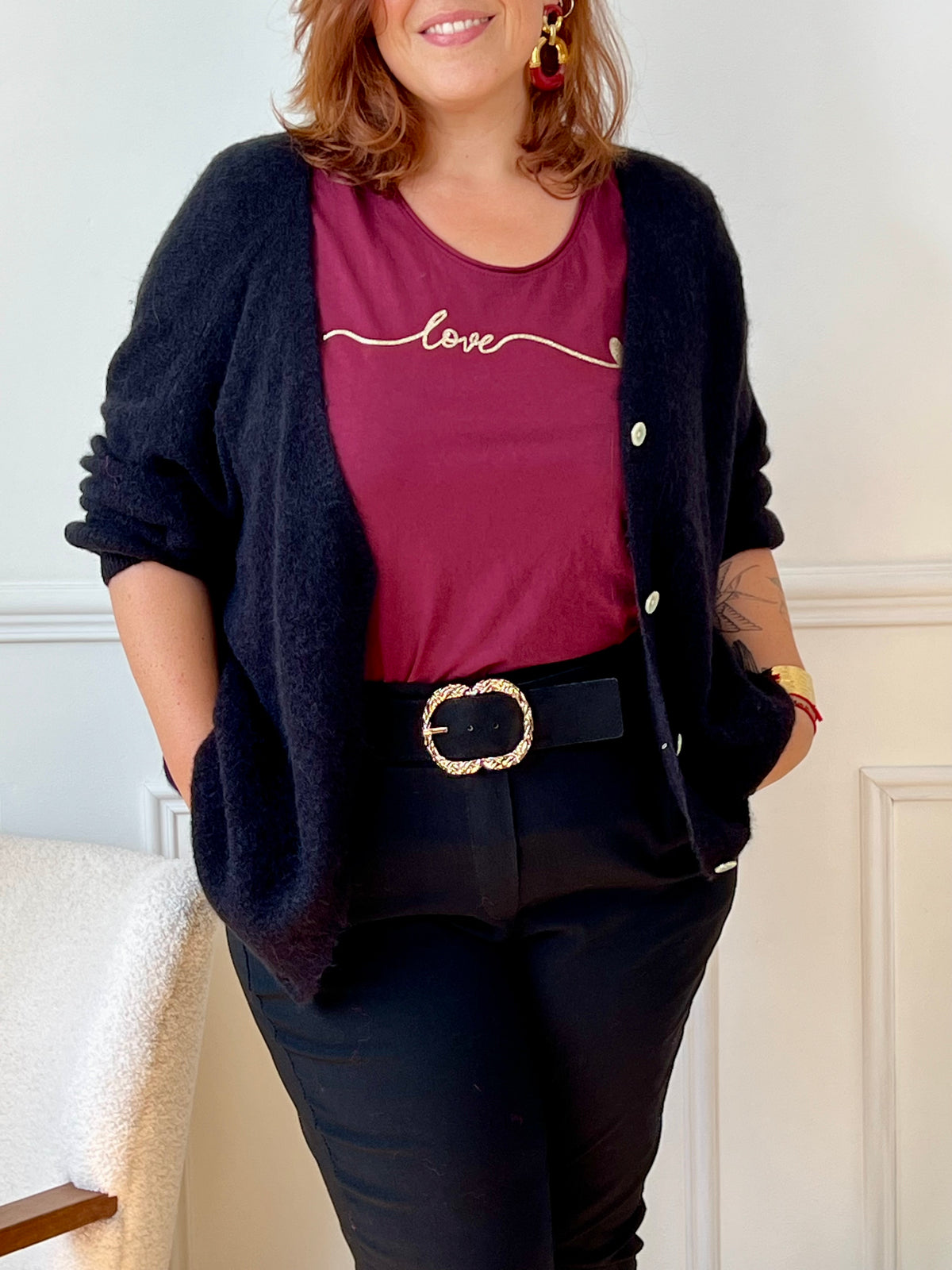 Tee-shirt bordeaux grande taille pour femme, manches courtes et col V élégant. Sa coupe moderne plus longue à l’arrière offre confort et style. Détail chic : inscription dorée "Love". Couleurs tendance bordeaux et doré, idéal pour un look casual et féminin