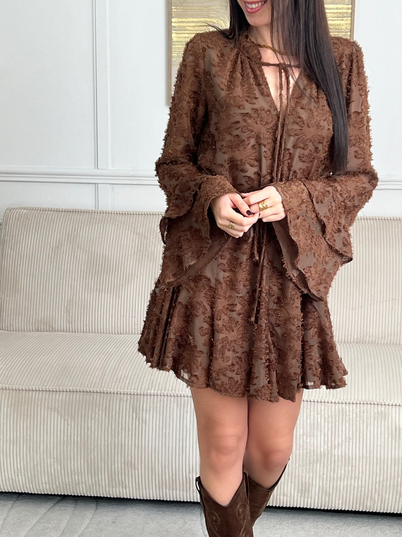 Délicate et féminine, cette robe marron clair séduit par ses volants élégants et son motif en relief au toucher doux. Une pièce pleine de charme, à la fois confortable et raffinée, parfaite pour toutes les occasions.