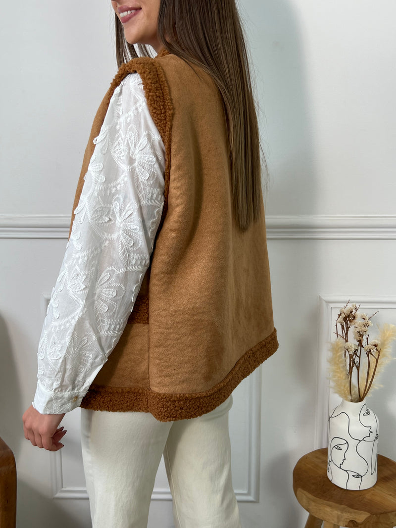 Adoptez un look tendance avec la veste sans manches : Talya en imitation daim camel. Avec ses 2 poches à l'avant, elle allie style et praticité. Son effet moumoute apporte une touche de douceur et de chaleur pour les journées fraîches. Soyez élégante et confortable en toutes occasions !