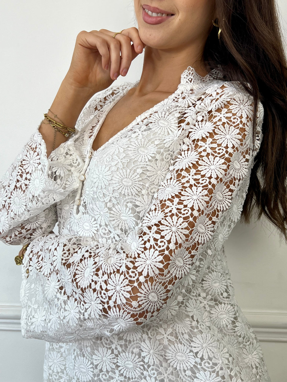 Une pièce féminine et élégante. Avec ses manches longues évasées et son col V orné de volants, cette robe en broderie ajourée est un véritable plaisir pour les yeux. Les boutons dorés et écrus ajoutent une touche de glamour, tandis que la doublure en bretelles assure un confort optimal.