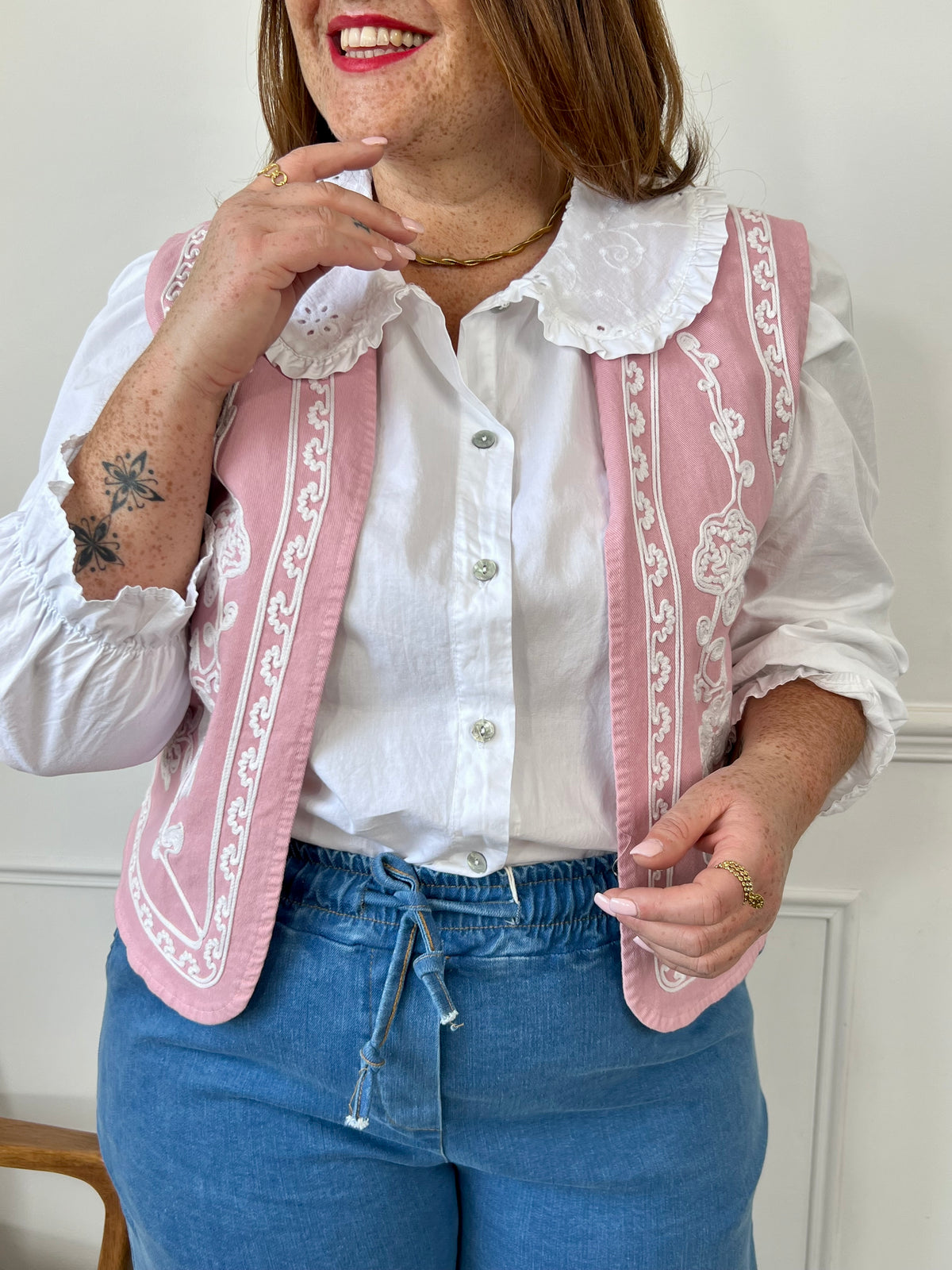 Un vrai bijou de douceur : cette veste rose sans manches séduit par sa coupe élégante et ses délicates broderies écru. Parfaite pour sublimer une tenue en toute légèreté avec une touche de charme bohème.