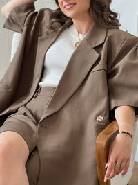 Ce bermuda taupe Delfine allie confort et praticité avec sa taille élastique au dos et ses passants pour ceinture. Il dispose de deux poches latérales et d’une poche arrière, offrant un espace de rangement fonctionnel. Sa fermeture éclair et son bouton à l’avant assurent un maintien sûr tout au long de la journée.