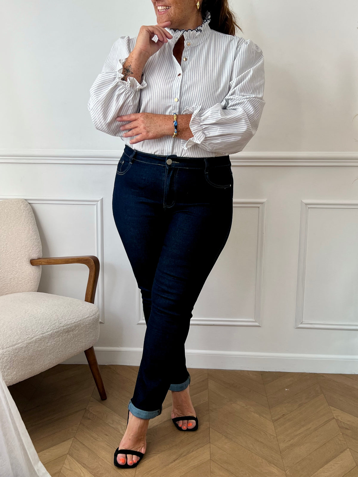 Chemise écrue à rayures bleues grande taille femme, idéale pour un look chic et confortable. Dotée de manches longues, d’un col montant festonné et de boutons dorés sur toute la longueur, elle allie élégance et modernité. Sa coupe fluide avec élastique aux manches assure un confort optimal. Confectionnée en 100 % coton, elle se porte facilement au quotidien.
