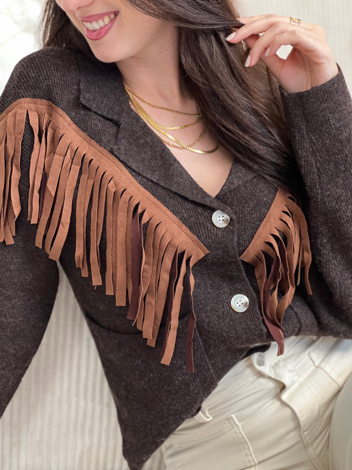 Chic et original, ce gilet marron col V se distingue par ses franges marron clair sur le devant. Une pièce pleine de caractère, à la fois douce, moderne et facile à associer au quotidien.