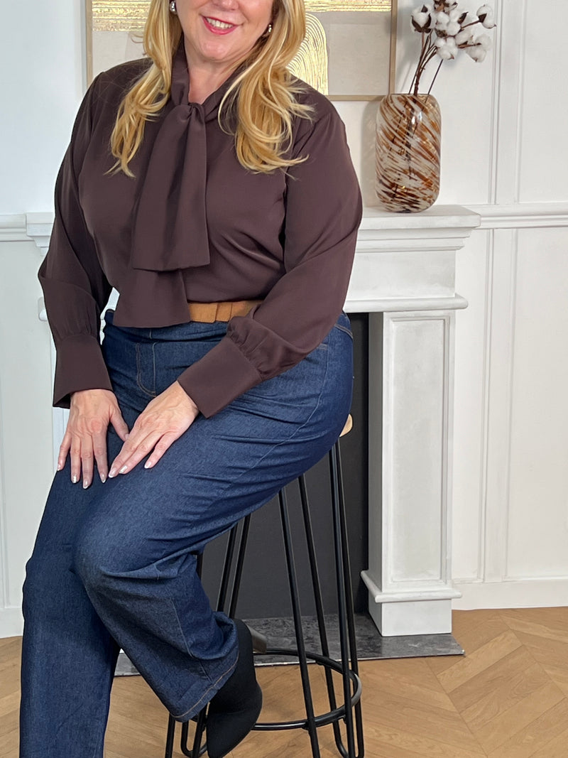 Sophistiquée et fluide, cette chemise marron séduit par son tombé élégant et son lien à nouer au col. Un détail raffiné qui apporte une touche de féminité et de charme à un style intemporel.