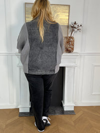 Cette veste grise bi-matière allie l'élégance du jean à la douceur de la maille pour un confort optimal. Dotée d’un col chemise classique, elle se ferme grâce à une rangée de boutons sur le devant et dispose de deux poches avant fermées par boutons, alliant praticité et style.