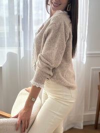Délicat et élégant, ce pull taupe se distingue par ses détails en broderie écru, subtilement placés au col et le long de la patte de boutonnage. Une touche raffinée qui apporte charme et authenticité à cette pièce intemporelle.