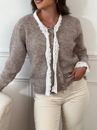 Élégant et raffiné, ce gilet taupe se distingue par ses délicats détails écru qui apportent douceur et contraste. Fermé par de charmants boutons en forme d’étoiles sertis de strass, il allie subtilement confort et éclat, parfait pour sublimer vos tenues avec une touche de chic discret.