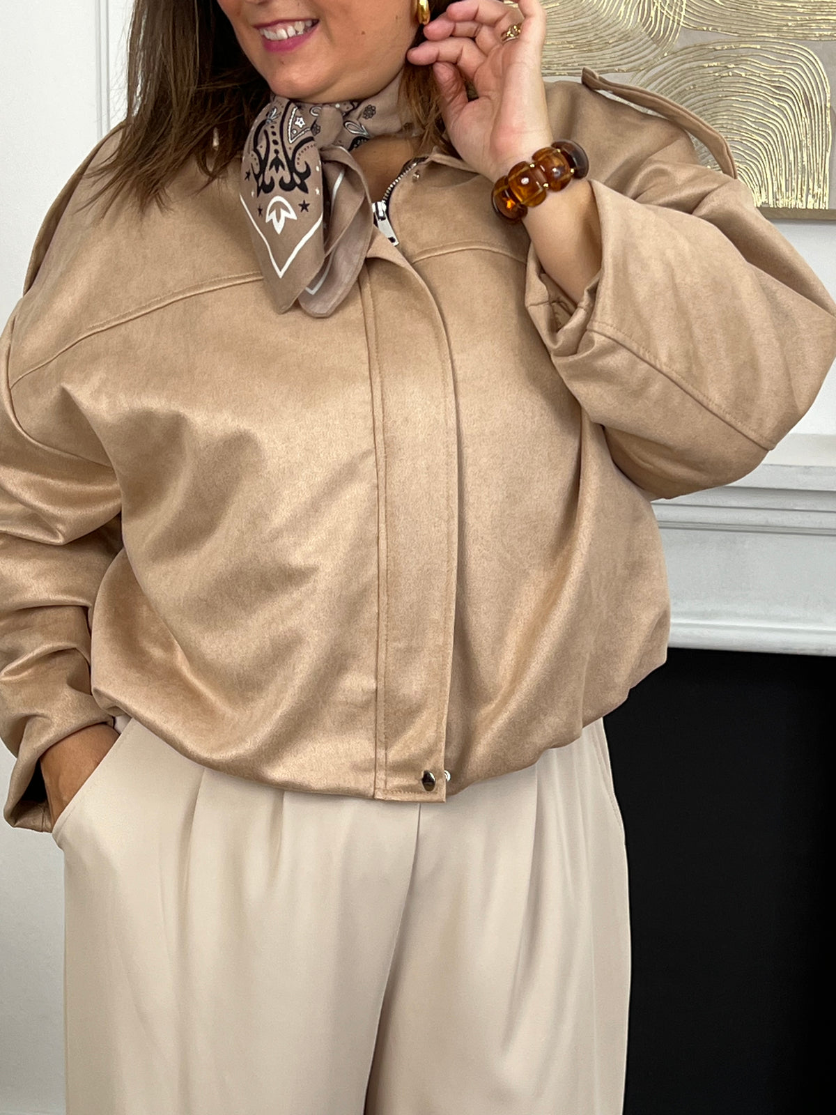 Cette veste courte style bombers se décline dans une teinte beige et tendance. Avec sa coupe moderne et son esprit casual-chic, elle apporte une touche de caractère à toutes vos tenues. Légère et polyvalente, elle se porte aussi bien au quotidien que pour compléter un look plus travaillé.