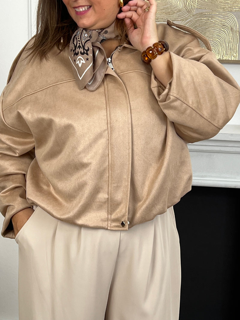 Cette veste courte style bombers se décline dans une teinte beige et tendance. Avec sa coupe moderne et son esprit casual-chic, elle apporte une touche de caractère à toutes vos tenues. Légère et polyvalente, elle se porte aussi bien au quotidien que pour compléter un look plus travaillé.