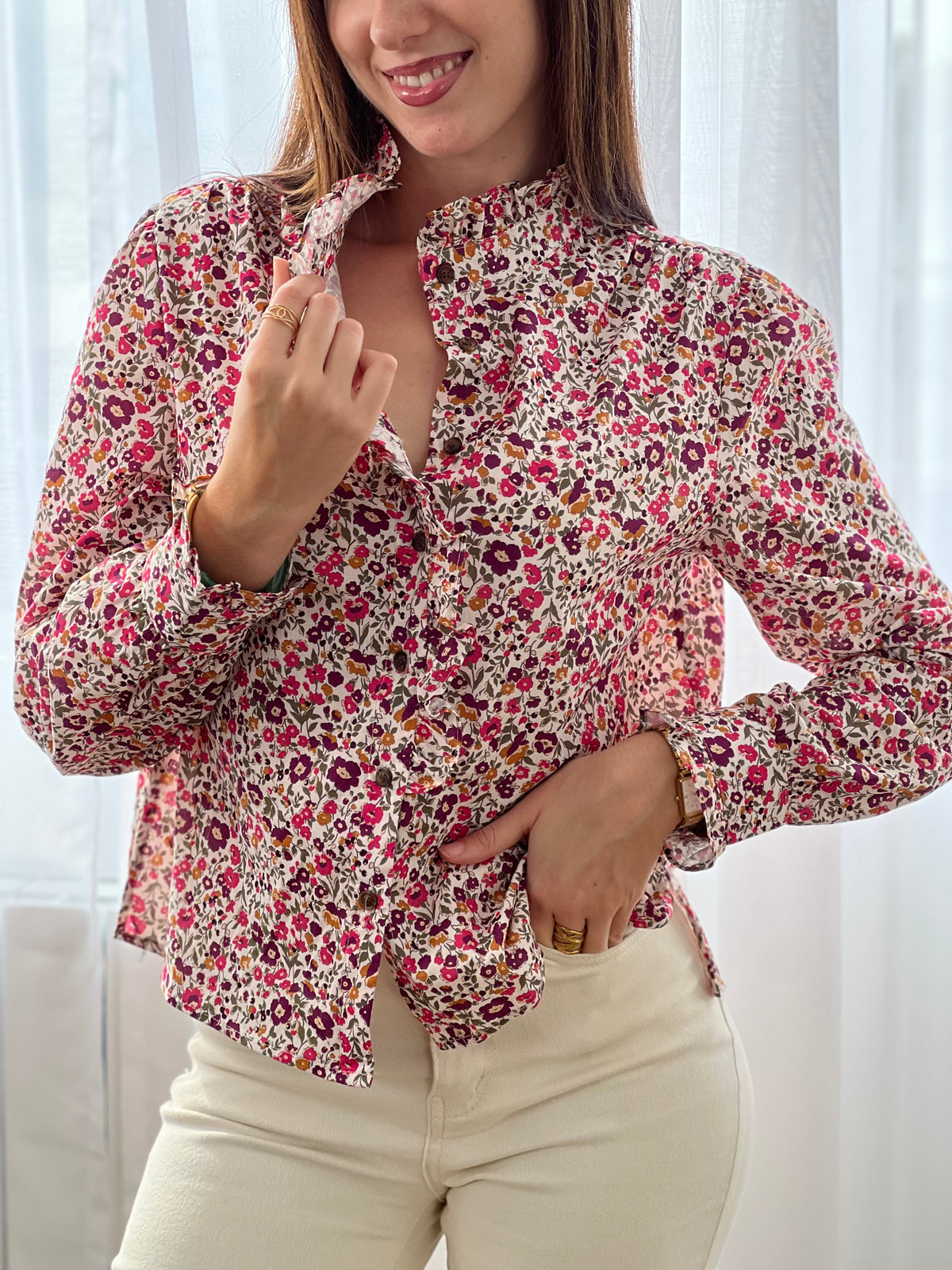 Cette chemise beige "Mia" avec motif floral offre une élégance délicate grâce à ses manches longues et ses volants raffinés au col, sur la longueur et aux manches.