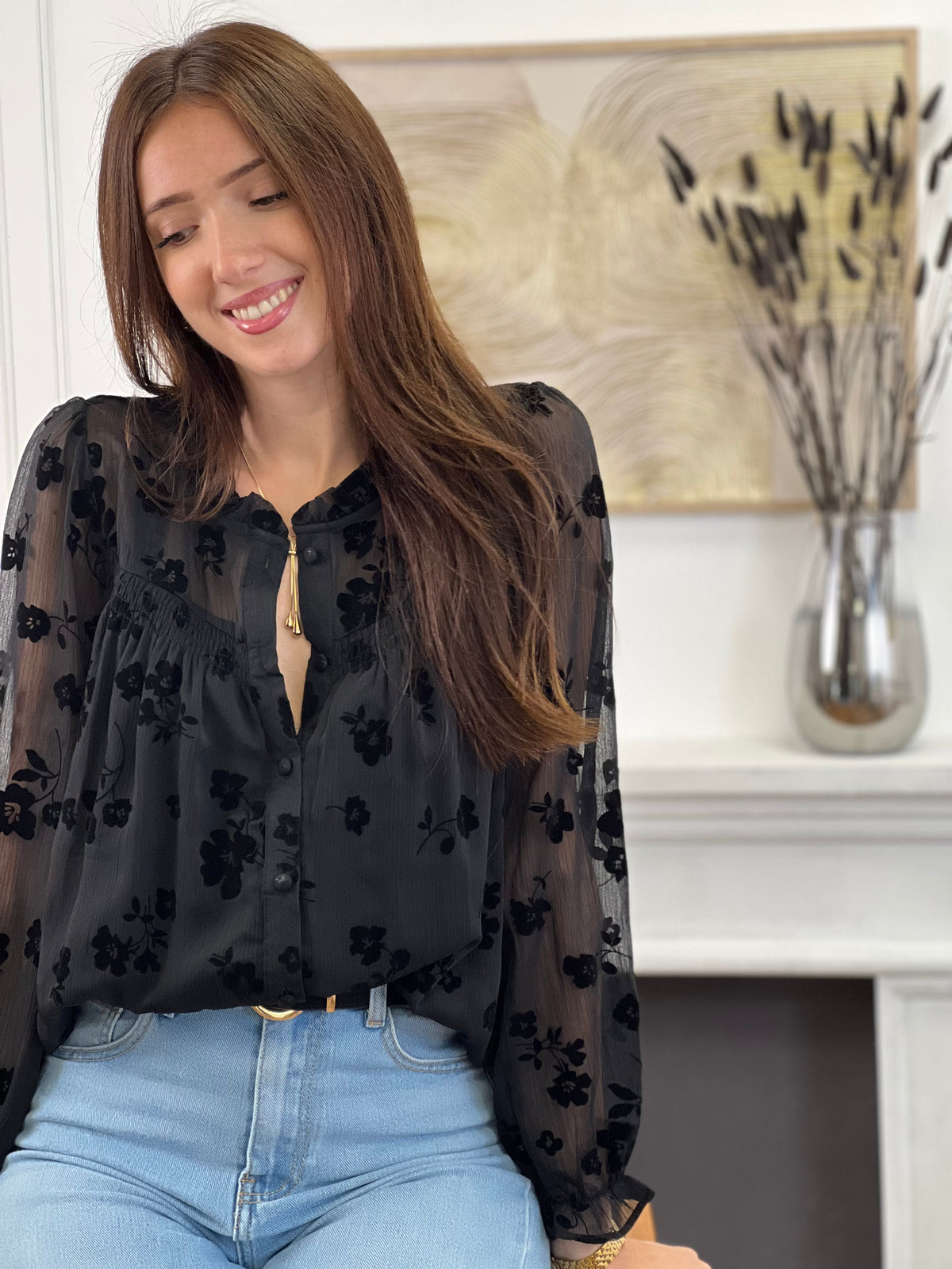 Cette chemise noire à motifs floraux Elenora allie élégance et délicatesse. Ses manches longues et son col rond apportent un charme classique, rehaussé par des volants subtils au col et aux manches.